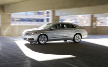 Серебристый Chevrolet Impala едет по многоэтажной парковке
